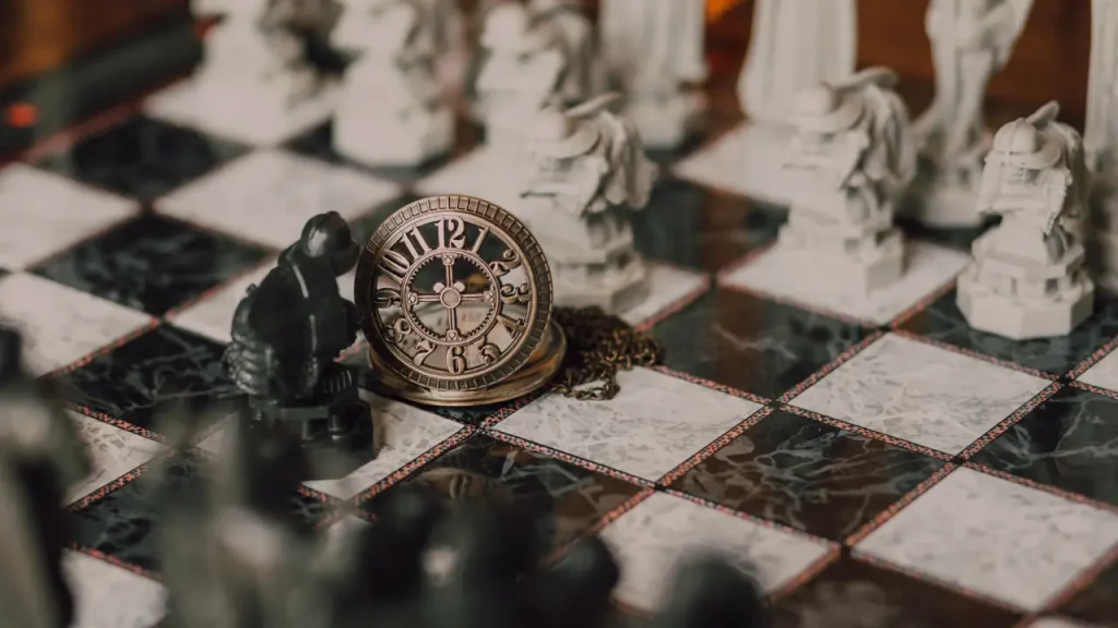 Vintage pocket watch beside chess pieces, which is also evoking the timed games of Indian chess history