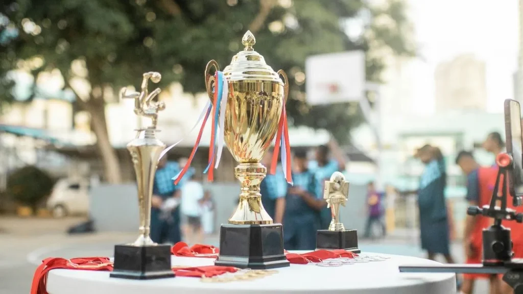 Trophy, medals, and ribbons at a sports event, representing how prize money and scale both define a tournament's size
