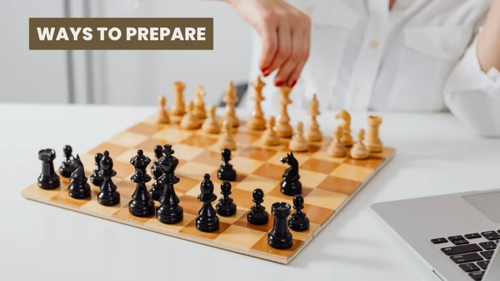 Player moving a piece on a wooden chess board with a laptop nearby while getting ready for a FIDE rated event